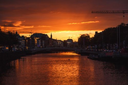 Dublín durante una colorida puesta de sol con nubes y gaviotas sobre el río liffey